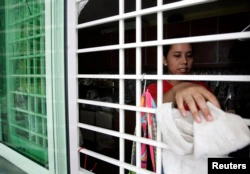 Seorang PRT asal Indonesia membersihkan rumah majikannya di Kuala Lumpur 26 Juni 2009. (Foto: Reuters)