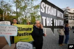 Para pengunjuk rasa berdiri di luar Pengadilan Hak Asasi Manusia Eropa di Strasbourg, Prancis untuk mendukung sidang gugatan enam remaja terkait kebijakan iklim 32 negara Uni Eropa, Rabu (27/9).