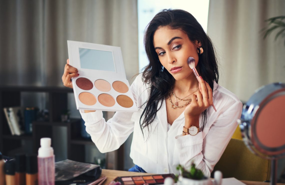 Shot of a influencer recording a makeup tutorial for her blog at home.