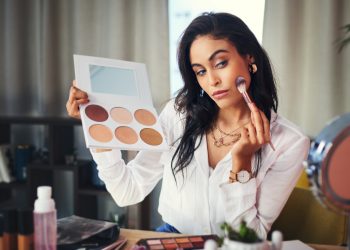 Shot of a influencer recording a makeup tutorial for her blog at home.