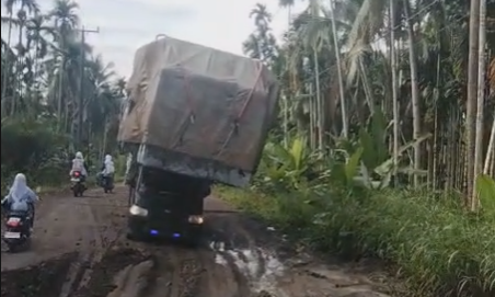 Bawa Muatan Berlebih, Mobil Tumbang di Jalan Rusak