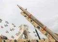 Iranian flags hang next to a missile on display during the forty-seventh anniversary of the Islamic Revolution in Tehran, Iran, February 11, 2026. Majid Asgaripour/WANA/Reuters