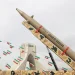 Iranian flags hang next to a missile on display during the forty-seventh anniversary of the Islamic Revolution in Tehran, Iran, February 11, 2026. Majid Asgaripour/WANA/Reuters