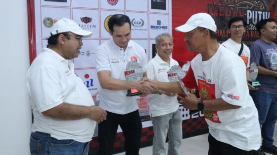 Rokky Irvayandi tengah bersalaman penyerahan trofi kemenangan