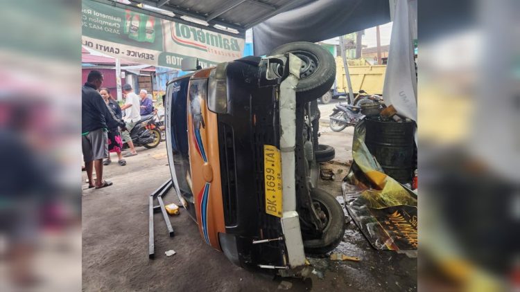 Kecelakaan mengakibatkan angkot terguling. ist