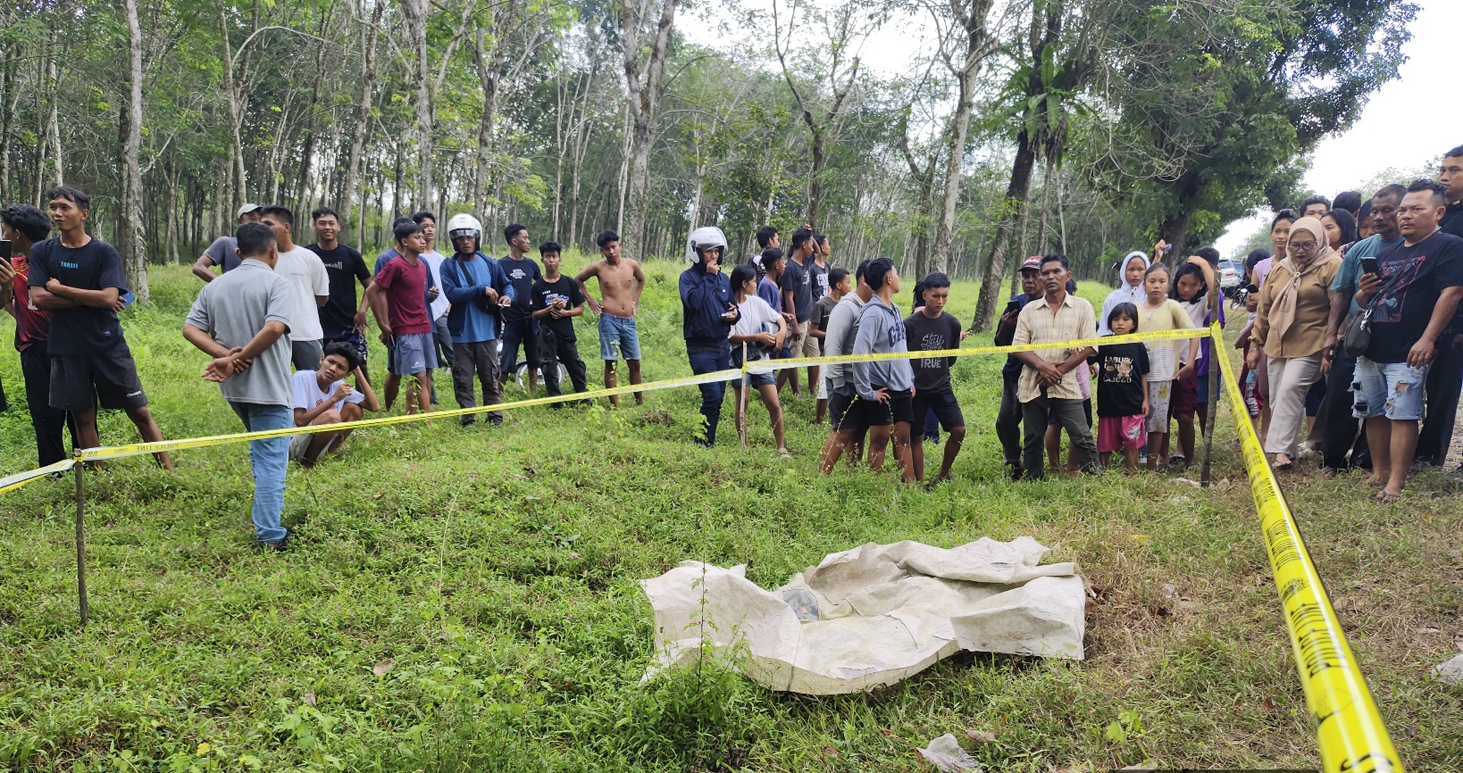 Petugas kepolisian memasang garis polisi di lokasi temuan mayat. Ist
