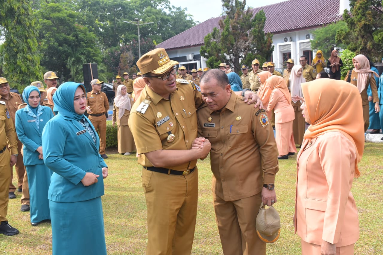 Bupati Asri Ludin (kiri) berjabat tangan dengan Timur Tumanggor di acara apel pengantar tugas. ist