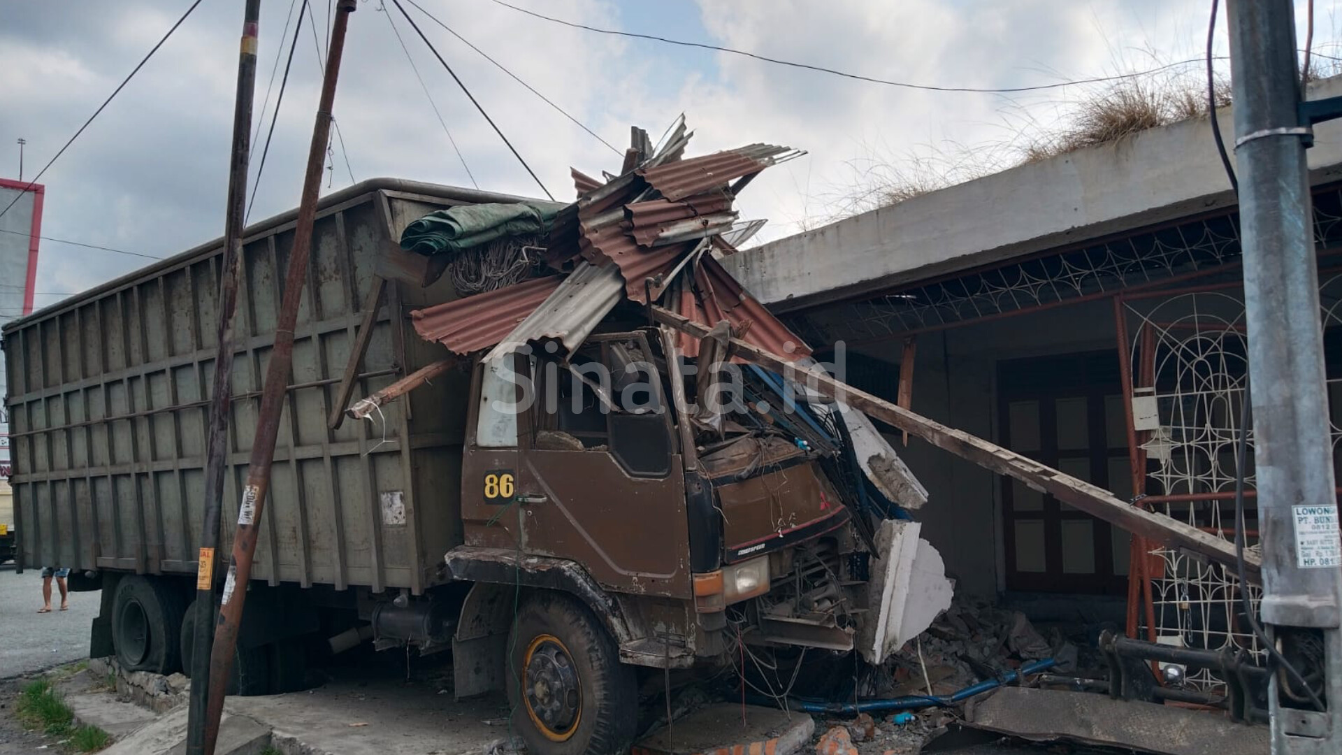 Truk diduga alami rem blong hantam rumah warga. (Foto: sinata/Hendri)