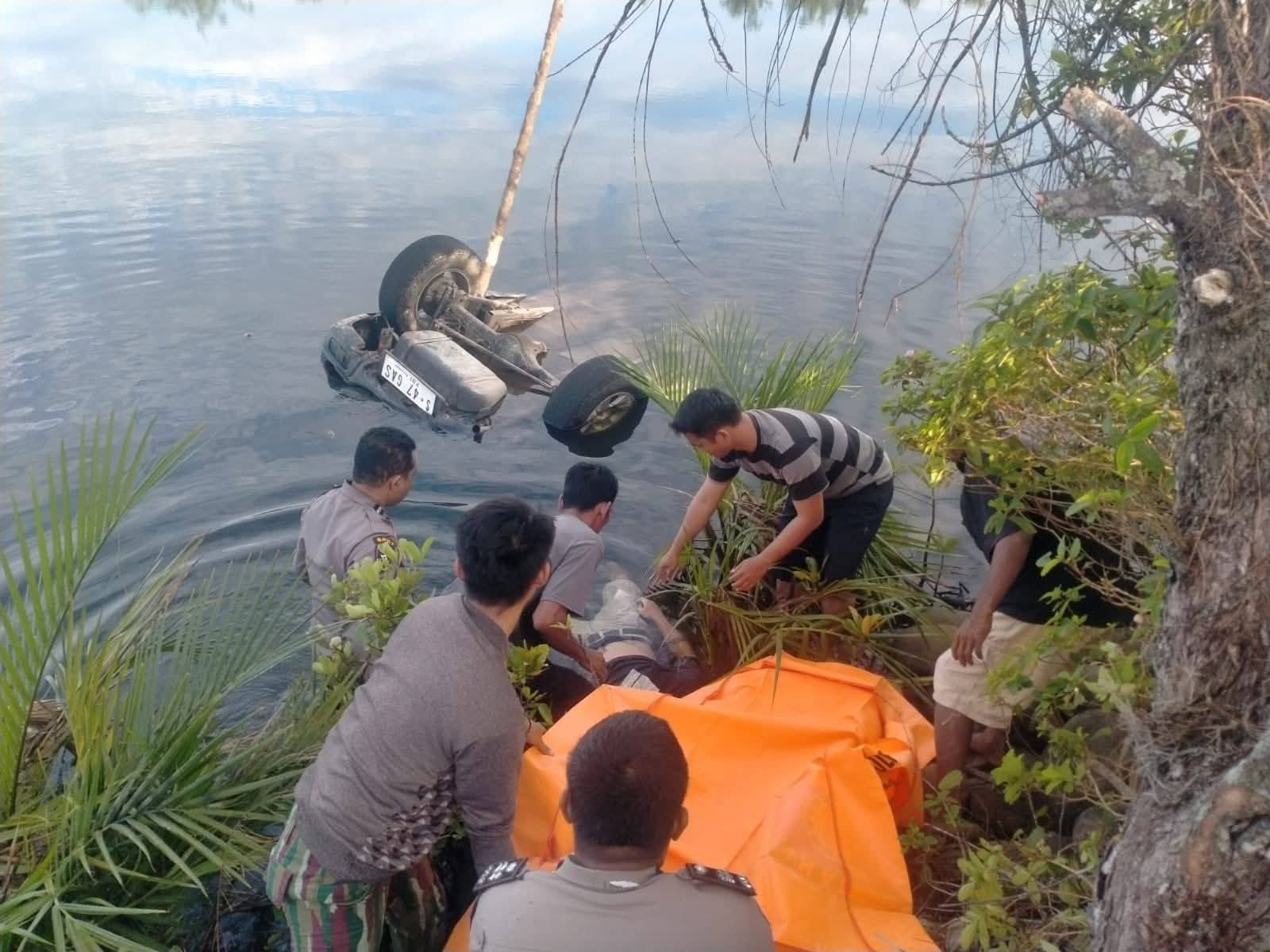 Petugas kepolisian mengevakuasi korban dari sungai. (foto: ist)