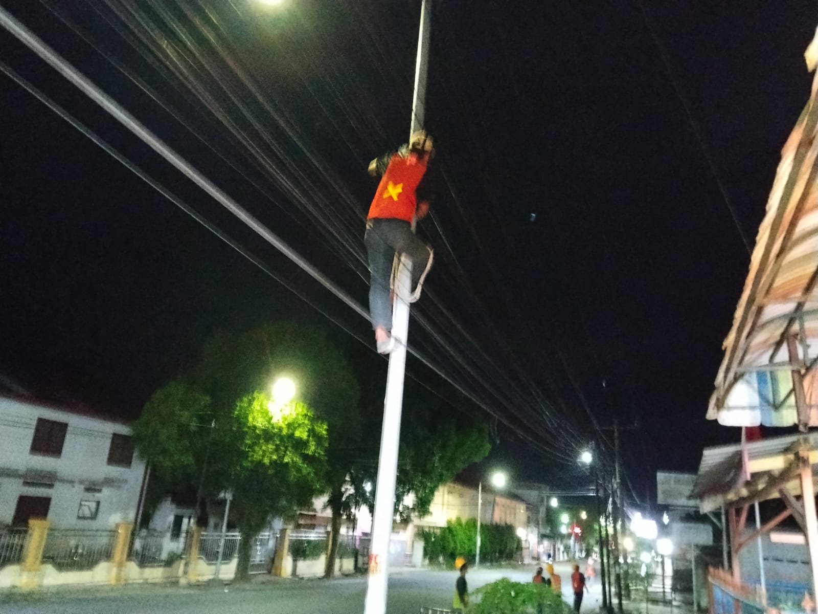 Pekerja memasang kabel internet di Jalan Melanthon Siregar pada malam hari. (foto: sinata/hendri)
