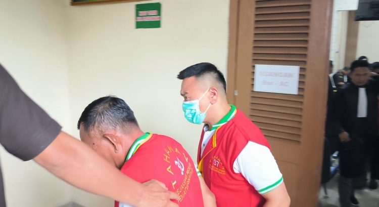 Terdakwa Jo (pakai masker) meninggalkan ruang sidang. (foto: sinata)