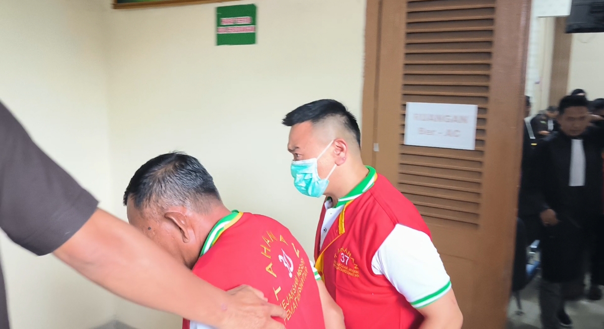 Terdakwa Jo (pakai masker) meninggalkan ruang sidang. (foto: sinata)