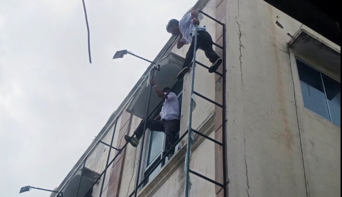 Dua pekerja saat  membantu proses eksekusi gedung di Jalan MH Sitorus, beraktivitas di ketinggian tanpa tali pengaman.