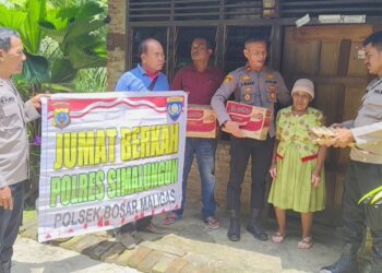 Kapolsek Bosar Maligas IPTU Sonni G Silalahi, SH memberikan sembako kepada Ibu Legyem.