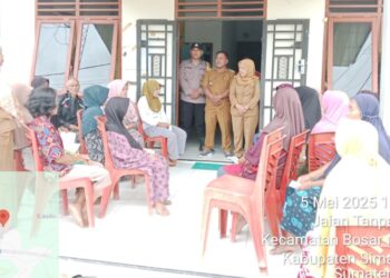 Bhabinkamtibmas Polsek Bosar Maligas, Aipda H. Sinaga, menghadiri dan memantau kegiatan pembagian BLT Dana Desa kepada masyarakat di Kantor Pangulu Mekar Rejo