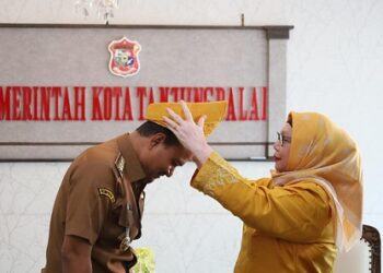 Ketua PD MABMI Tanjungbalai, Hj Delima memakaikan Tanjak Melayu bewarna kuning emas kepada Wali Kota Tanjungbalai, Mahyaruddin Salim