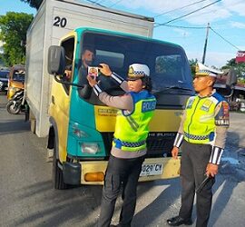 Kanit Turjawali IPDA Horas Tambunan, Kanit Kamsel IPDA Serly Tarigan dan Kanit Gakkum IPDA Syah Edi S. Purba SH melaksanakan pembagian brosur tertib berlalu lintas dan stiker Layanan Polisi 110 di Jalan Medan