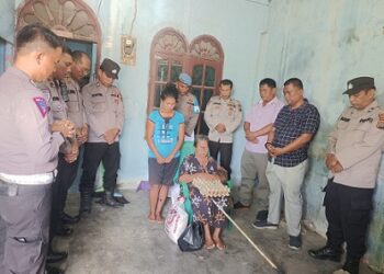 Personil Polres Tanjungbalai saat memberikan bansos kepada Ibu T. br. Gultom