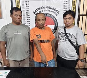 Tersangka Ropandi beserta barang bukti diapit personil Polsek Bosar Maligas saat diserahkan di Kantor Sat Resnarkoba