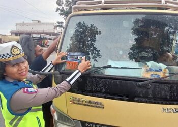 Kanit Kamsel IPDA Serly Tarigan SH melaksanakan pembagian brosur dan stiker larangan Overload dan Overdimensi di Jalan Parapat