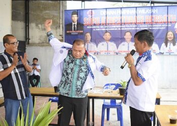 Ketua Umum Sopo ATRestorasi Bersatu, Antonius Devolis Tumanggor memberikan baju kepada Sekda Kabupaten Deli Serdang, H. Timur Tumanggor yang secara resmi bergabung ke Sopo ATRestorasi Bersatu. (Foto Ist)