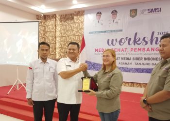 Ketua SMSI Sumut Erris J. Napitupulu saat menerima plakat penghargaan di Workshop SMSI Astab