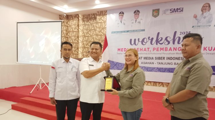 Ketua SMSI Sumut Erris J. Napitupulu saat menerima plakat penghargaan di Workshop SMSI Astab