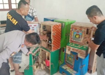 Personil Polsek Bahorok memeriksa mesin judi jackpot dan ikan-ikan di SD Negeri 050655 di Desa Lau Damak, Kecamatan Bahorok, Langkat. (Foto Ist)