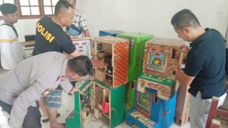 Personil Polsek Bahorok memeriksa mesin judi jackpot dan ikan-ikan di SD Negeri 050655 di Desa Lau Damak, Kecamatan Bahorok, Langkat. (Foto Ist)