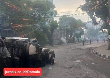Sejumlah petugas kepolisian membuat blokade menghalau massa yang berunjuk rasa di Jalan Imam Bonjol, Medan, dan tampak massa melepaskan petasan ke arah polisi. (Foto Romulo)