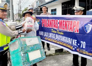 Kanit Regident IPTU Elon Sitinjak SH saat berikan sembako kepada masyarakat Pedagang Es Sepeda Keliling