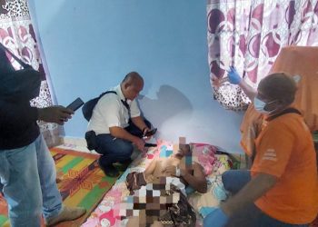 Kanit Reskrim IPTU Fritsel G.Sitohang, SH. MH bersama Tim Inafis saat melihat kondisi jenajah korban di rumah duka