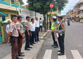 Kanit Kamsel IPDA Serly Tarigan bersama personil Kampanye Keselamatan dengan berikan alat bantu Gatur Lalin dan pembinaan kemampuan kepada Satpam Sekolah YP Tamsis
