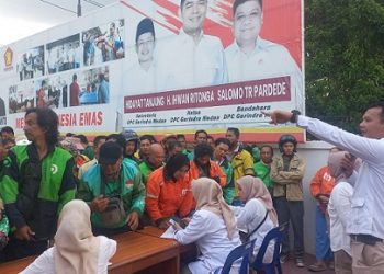 Jajaran pengurus DPC Gerindra Kota Medan membagikan beras kepada para pengemudi ojek online (ojol) di Kota Medan. (Foto Romulo)