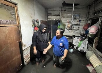 Anggota DPRD Kota Medan, Lailatul Badri meninjau banjir yang mengenang kawasan Gg Tahir, Pulo Brayan Darat I, Medan Timur. (Foto Romulo)