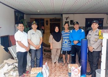 Bhabinkamtibmas Kelurahan Setia Negara AIPTU Januar Butar butar melaksanakan pendampingan pemberian bantuan kepada masyarakat terdampak bencana alam hujan deras dan angin kencang