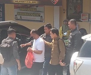 Tersangka Tohom Lumbangaol saat dibawa Kanit Tipikor IPDA Lizar Hamdani SH bersama Penyidik Pembantu untuk dilimpahkan ke Kejari Pematangsiantar