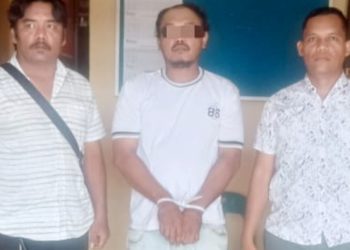 Tersangka MIS diapit Kanit Reskrim IPDA Juhandya Malau SH dan Tim