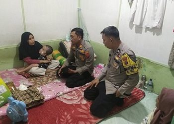 Kapolsek Teluk Nibung AKP Rinaldi, SH. MH saat berikan bantuan kepada Yeni ibu balita penderita Hidrosefalus