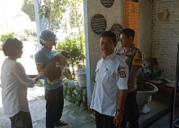 Bhabinkamtibmas Kelurahan Teladan BRIPKA Irwan Surya Darma mendampingi petugas kesehatan melakukan Vaksinasi Rabies hewan peliharaan masyarakat di Jalan Simbolon