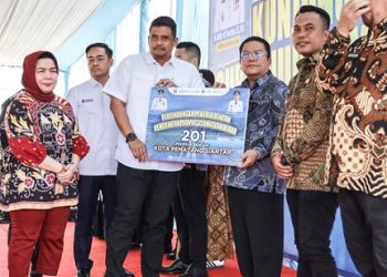 Wali Kota Pematangsiantar Wesly Silalahi SH MKn menerima secara simbolis Kartu BPJS Ketenagakerjaan diperuntukkan bagi pekerja rentan yang diserahkan Gubernur Sumut Muhammad Bobby Afif Nasution SE MM