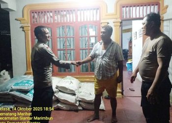 Kanit Intelkam IPDA Edison Sitohang bersama Bhabinkamtibmas mendistribusikan bantuan pupuk kepada masyarakat, Bapak Kompol Purn. P. Hutasoit