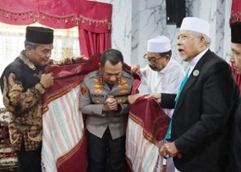 Kapolrestabes Medan Kombes Pol Dr.Jean Calvijn Simanjuntak, S.I.K, M.H disematkan ulos oleh Buya Syech Ali Akbar Marbun dan tokoh agama lainya. (Foto Ist)