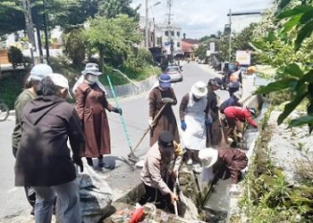 Bhabinkamtibmas AIPTU Yunus Sembiring ikut serta membersihkan jalan FKTHB Keuskupan Agung Medan Vikariat Siantar Simalungun.