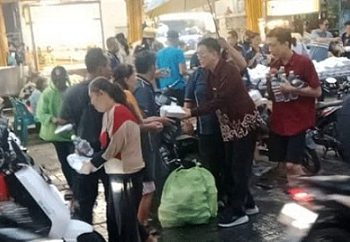 Ketua DPC PDI Perjuangan Kota Medan, Hasyim SE, bersama Komunitas Wu Xing (5 Elemen), membagikan paket makanan bergizi kepada warga, Sabtu (18/10) kemarin ditengah guyuran hujan. (Foto Ist)
