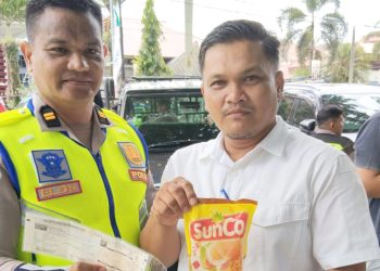 Kanit Regident IPTU Elon Sitinjak saat memberikan minyak goreng kepada pengendara Pengendara Langsung Bayar Pajak Kendaraan