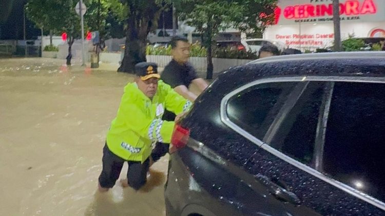 Kapolda Sumut, Irjen Pol Whisnu Hermawan Februanto, S.I.K. M.H turun langsung ke lokasi banjir di kawasan Jalan Jenderal Sudirman, Medan dan membantu pemilik kendaraan terjebak banjir. (Foto Ist)