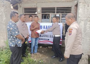 Kanit Gakkum Sat Lantas IPDA M. Silitonga memberikan bantuan sembako kepada Bapak R. Sibuea.