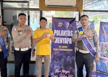 Kanit Regident Sat Lantas IPTU Elon Sitinjak SH saat serahkan SIM telah diterbitkan kepada seorang warga pemohon