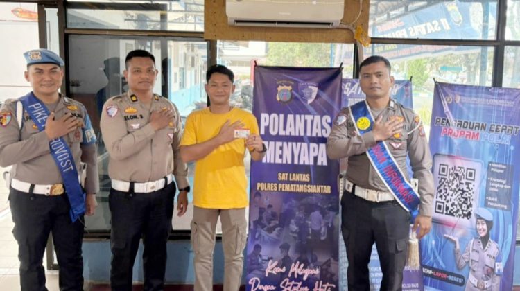 Kanit Regident Sat Lantas IPTU Elon Sitinjak SH saat serahkan SIM telah diterbitkan kepada seorang warga pemohon